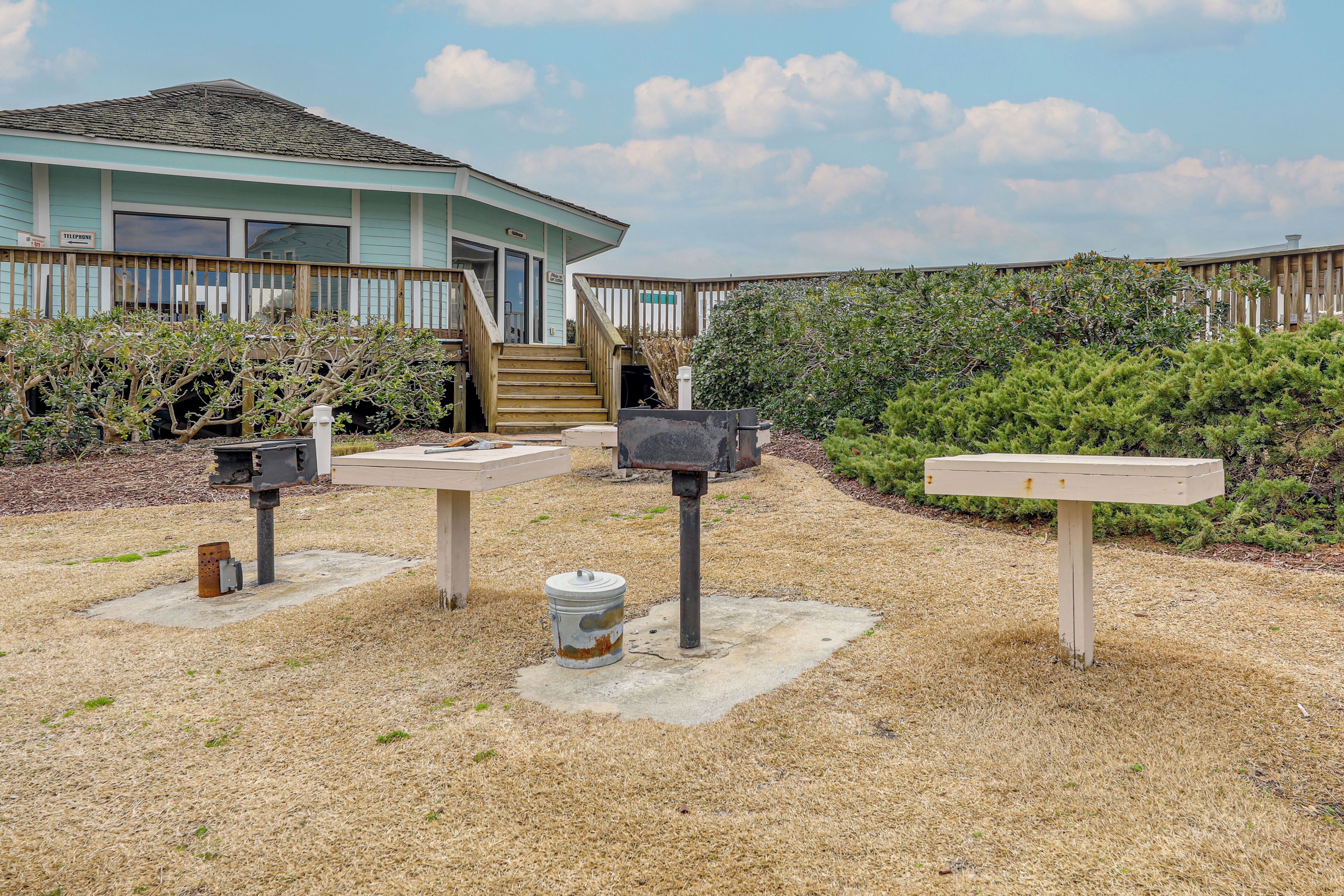 A beachfront house with a wooden deck, a staircase leading to the entrance, and a mailbox.