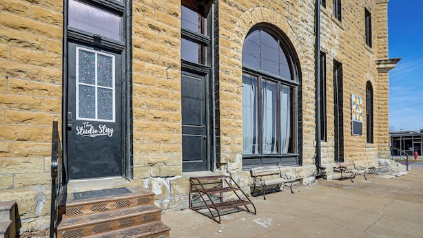 Un edificio de piedra con una puerta negra que dice "The Studio Stay".