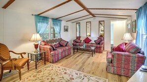 A living room with a wooden ceiling, two sofas, a coffee table, a chair, and a rug. - Cabin w/ Lake Access in Fort Mccoy, Pets Welcome! (Fort McCoy)