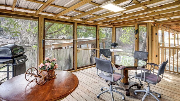 A covered patio with a wooden table, chairs, and a grill. - Cabin w/ Lake Access in Fort Mccoy, Pets Welcome! (Fort McCoy)