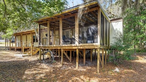 A wooden cabin with a porch and a covered outdoor area, surrounded by trees. - Cabin w/ Lake Access in Fort Mccoy, Pets Welcome! (Fort McCoy)