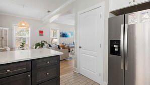 Una cocina con una isla grande, refrigerador de acero inoxidable y un comedor con mesa y sillas.