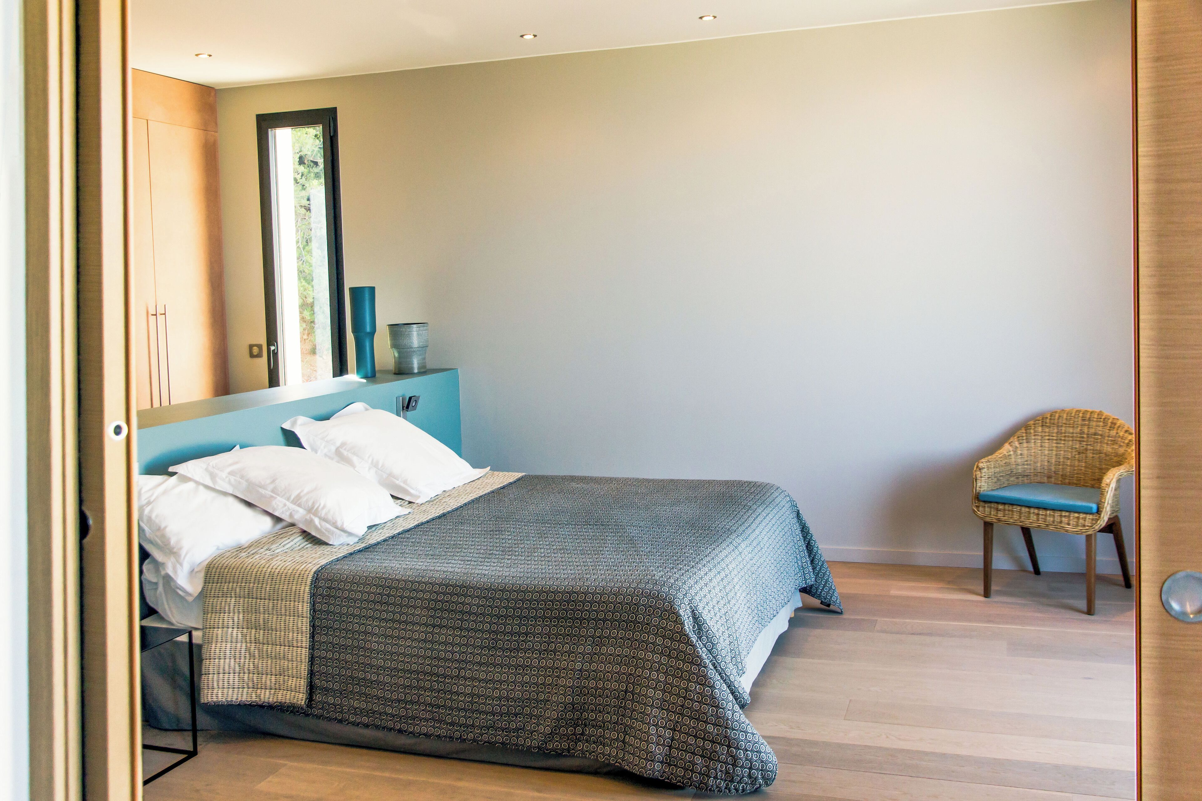 Un dormitorio con cama, una silla, cómoda y espejo.
