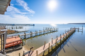 A pier extending into calm water with a clear sky above.