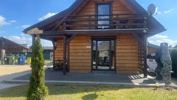Un bâtiment en bois avec un toit en pente, une enseigne indiquant « JEDREK » et une antenne parabolique.