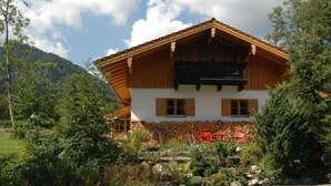 Un bâtiment de style chalet, doté d’un toit en pente, d’une façade en bois et de fondations en pierre.