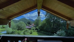 Une structure en bois offrant une vue sur un paysage verdoyant, avec des arbres et une maison.