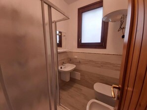A bathroom with a toilet, sink, and shower area. - Apartment With sea View and Great Roof Terrace (Santa Teresa di Gallura)