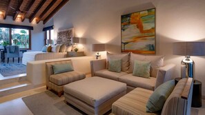 A modern living room with a sofa set, a coffee table, and a dining area with a chair and table. - Casa Serena in Punta Mita (Punta de Mita)