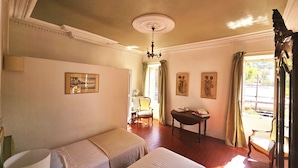 A hotel room with two beds, a table, a chair, and a view of the outside. - Family home, sleeps 8, terrace with panoramic view in Porquerolles (Hyères)