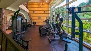 A gym with cardio equipment, weight machines, and a staircase. - Waterfront Balcony Condo Beach Access Hot Tub (Ruskin)