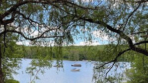 A wooden bench in a park with a lake and boats in the background. - Wildflower Cabins Limit 6 3 Bedroom Villa (Naples)