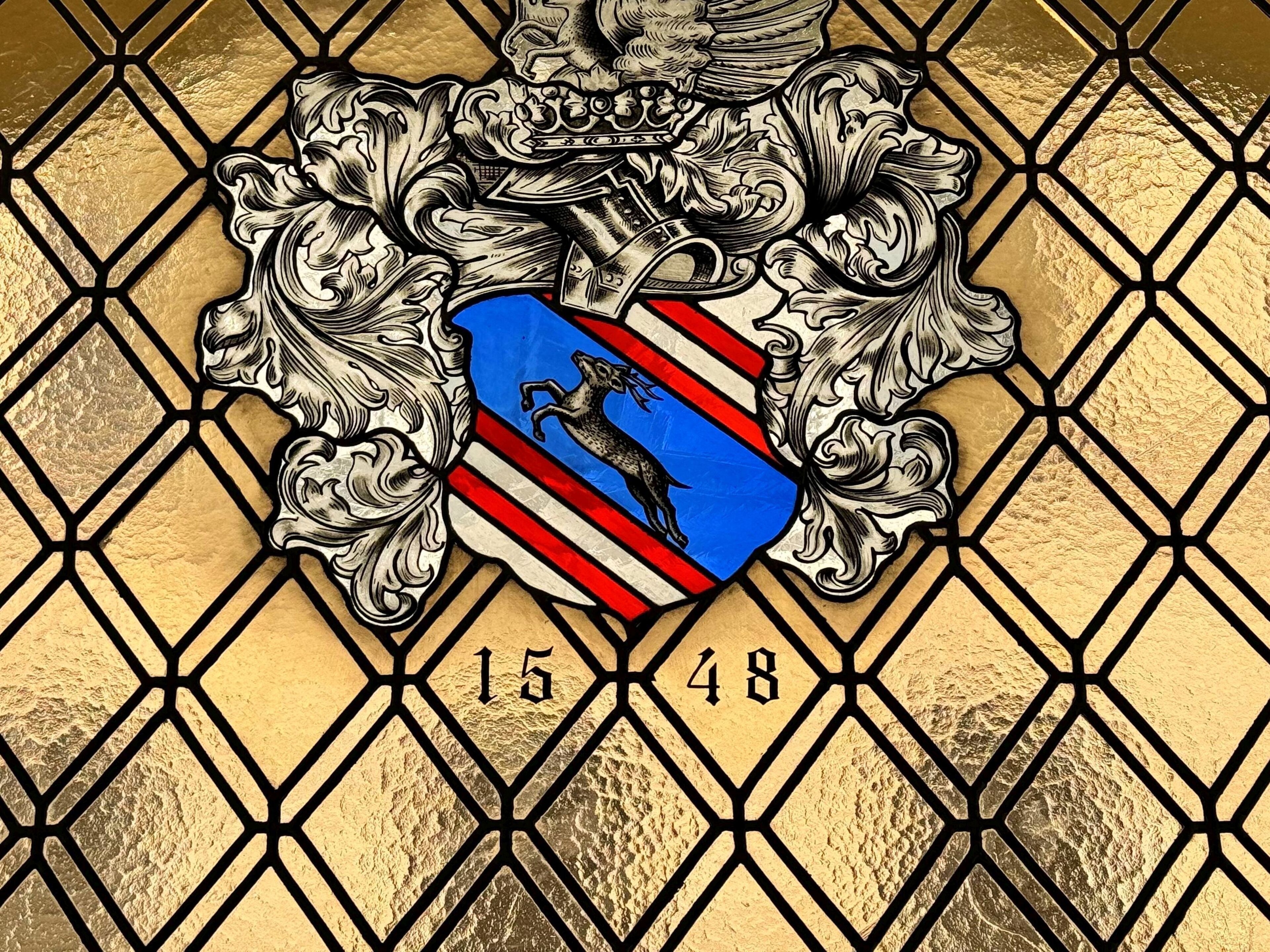 A coat of arms with a shield, a lion, and the numbers 15 and 48.