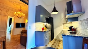 Uma cozinha moderna com armários escuros, uma geladeira preta e um painel de backsplash estampado.