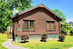 A log cabin with a green roof, two windows, and a sign reading 'Skiy Dippin'. - Skinny Dippin 2 Bedroom Cabin (Pigeon Forge)