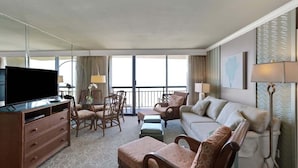A hotel room with a flat-screen TV, a sofa, a loveseat, a dining table with chairs, and a balcony with a view. - Two Pina Coladas At San Luis Resort 2 Bedroom Condo (Galveston)