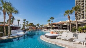 A swimming pool with lounge chairs and palm trees. - Two Pina Coladas At San Luis Resort 2 Bedroom Condo (Galveston)