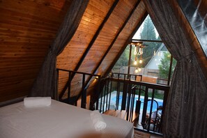 Une chambre avec un plafond en bois et une vue sur une piscine à l’extérieur.
