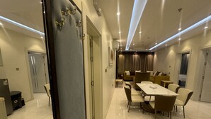 Una habitación de hotel moderna con zona de comedor que incluye una mesa de mármol y asientos cómodos.