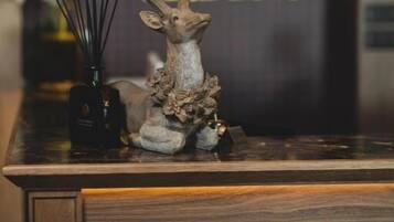 A reception desk with a deer head sculpture, a vase with flowers, and a sign with Chinese characters.