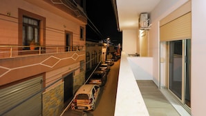 Una calle estrecha en la ciudad, con coches aparcados y edificios a ambos lados.