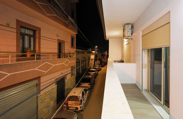 Una calle estrecha en la ciudad, con coches aparcados y edificios a ambos lados.
