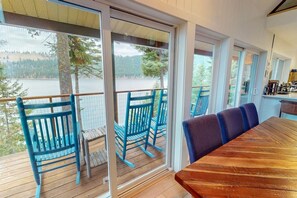 Eine Terrasse mit Holzboden, einem Holztisch und blauen Stühlen.