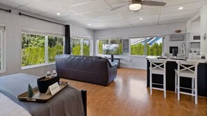 Een moderne hotelkamer met een groot bed, een bank, een zithoek en een kitchenette.