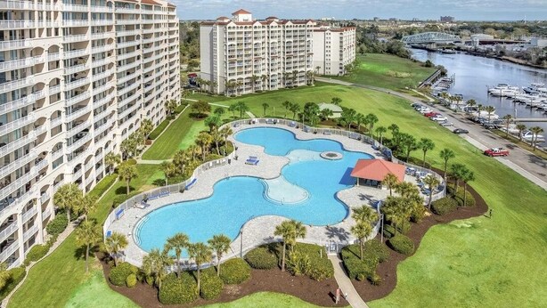 A hotel with a large pool, multiple balconies, and a marina. - River Crossing 332 Gated Community with Great Pool! New On Program! (North Myrtle Beach)