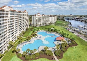Hotel com uma piscina grande, várias varandas e um porto de recreio.