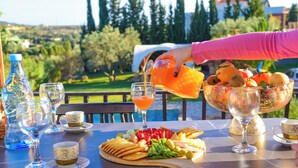 Une table dressée avec une variété de plats et de boissons, et en arrière-plan, une vue panoramique sur le paysage extérieur.
