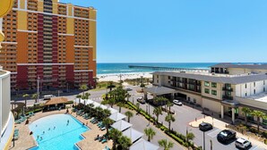 Un hotel con piscina, vista a la playa y un muelle.