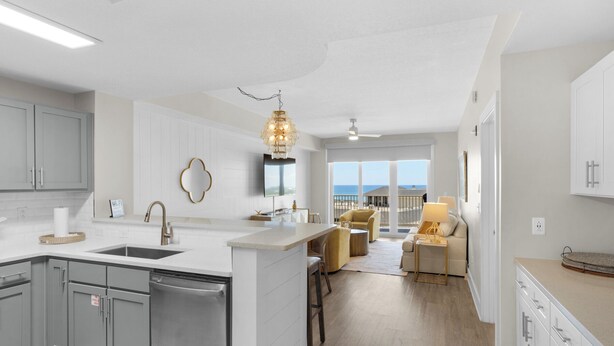 Una cocina moderna con una isla central, armarios grises y vistas al exterior.