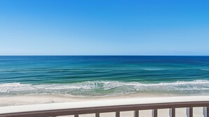 A beach view with clear blue water and a sandy shore. - Emerald Isle 1102 - Front row beach chair service included! Affordable rates! (Panama City Beach)
