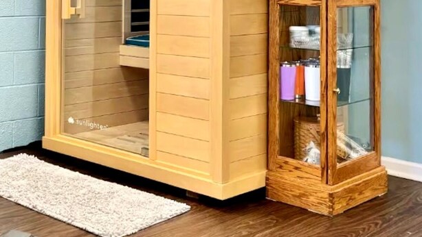A corner room with a sliding glass door closet, a wooden cabinet with glass doors, and a small rug on the floor. - Private Sauna, Fireplace and Country Views (Mount Airy)