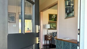 A room with a dark wooden door, a blue cabinet with intricate carvings, a patterned rug, and a painting on the wall. - Private Sauna, Fireplace and Country Views (Mount Airy)
