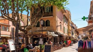 A street with outdoor seating, a café named 'Le Sud', and a clothing stall. - Beautiful villa in the trees with air-con and pool (Les Arcs)