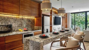 Uma cozinha moderna com bancadas de granito, armários de madeira e iluminação pendente.