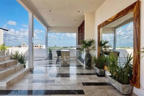 A spacious indoor area with a view of the sky, featuring a marble floor, a staircase, and several potted plants. - Beautiful 2-bedroom apartment "Casa Lumina" in Narai Aldea Zama by HEUSHAVEN, Tulum. Features a private terrace, full kitchen, fast WiFi, rooftop pool, gym, and shared amenities. Prime location between downtown Tulum and the beach road. (Tulum)