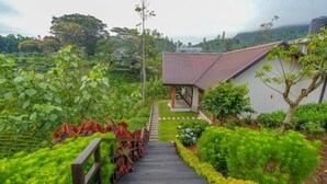 Eine Treppe führt zu einem Haus, das von üppigem Grün umgeben ist und einen Blick auf die Landschaft bietet.