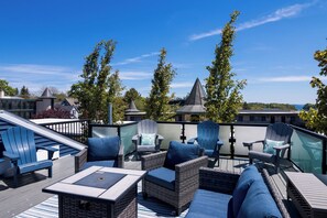 A rooftop deck with wicker furniture, a slide, and a view of the cityscape.