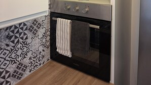 A compact kitchen with a built-in oven, a coffee maker, and a potted plant on a shelf. - T2 Duplex in hyper-centre - Quiet, independent access (Vienne)