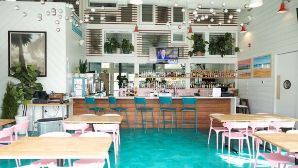 Un espace bar comprenant un comptoir, des tabourets de bar et une variété de bouteilles.