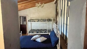 Una habitación con literas, una mesita pequeña y un candelabro.