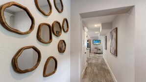 A hallway with a series of wooden mirrors on the wall and a television in the background. - Island House – Walk to Siesta Key Beach! (Siesta Key)
