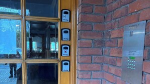 A wooden door with a glass panel and a brick wall with a security keypad and an elevator control panel. - Corraleith/Cozy 2 Bedroom/2 Bath Leith Flat: Tram at Ocean Terminal: Parking (Edinburgh)
