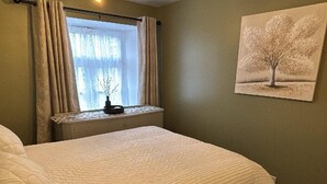 A bedroom with a bed, a window with curtains, a wall-mounted picture, and a ceiling light. - Corraleith/Cozy 2 Bedroom/2 Bath Leith Flat: Tram at Ocean Terminal: Parking (Edinburgh)
