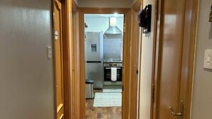 A hallway with wooden doors leading to a kitchen area. - Corraleith/Cozy 2 Bedroom/2 Bath Leith Flat: Tram at Ocean Terminal: Parking (Edinburgh)