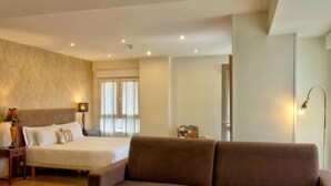 A hotel room with a bed, a brown sofa, a nightstand with a lamp, and a window with curtains. - Hospedaje Boutique Weber's (Gijón)