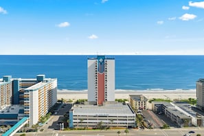 A high-rise hotel with a central tower, a parking garage, and a beachfront view. - The Palace Resort #1114 (Myrtle Beach)